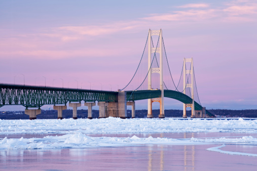 Winter landscape at twilight of the Mackinac Bridge and the frozen Straits of Mackinac, Michigan's Upper and Lower Peninsulas, USA