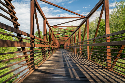 bike trail and a long footbridge over a river - Cache la Poudre River in Fort Collins, Colorado
