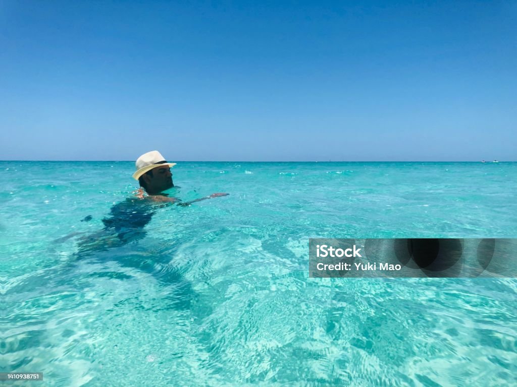 Man swimming in a blue transparent water on Varadero beach, Cuba Cuba Stock Photo