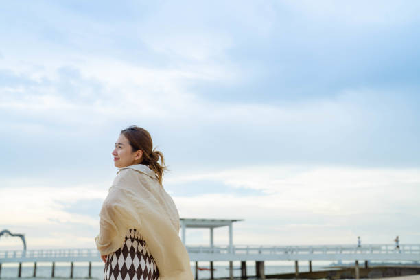 Charming Asian young woman breathing fresh air at summer beach.