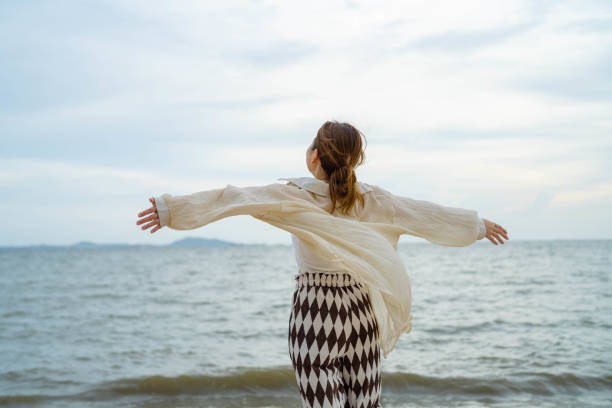 istock Young woman enjoying her walk on the beach 1410940635