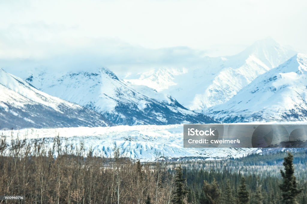 Matanuska Glacier with Chugach Mountain Backgrounds The Matanuska glacier, located about an hour from Anchorage, Alaska. The is the largest glacier that is able to be reached by a car. Traveling along the Glenn Highway, the glacier spreads out across the valley. On this day it was a beautiful sight with the Chugach Mountains rising in the distance. Adventure Stock Photo