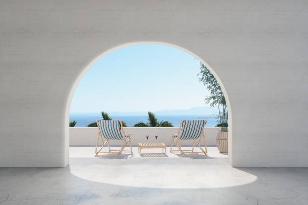 라운지 의자가있는 발코니와 아치를 통한 바다 전망 - indoors window elegance tranquil scene 뉴스 사진 이미지