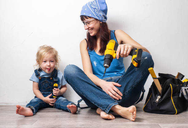 one parent: mom performs men's housework with a small daughter and sat down to rest at the white wall. - independence business women manual worker imagens e fotografias de stock