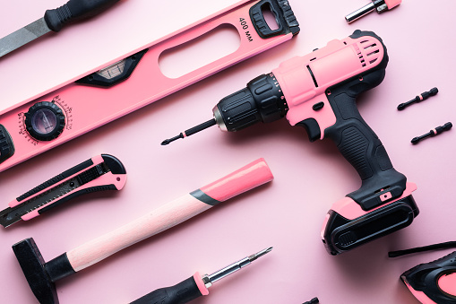 Provocación creativa: una disposición plana de las herramientas de mano rosa sobre un fondo rosado. photo