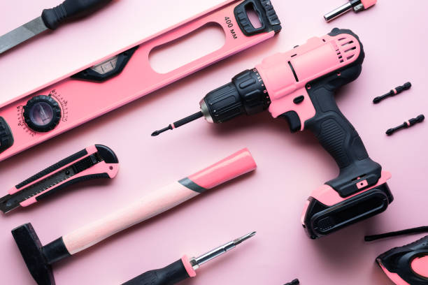творческая провокация: плоская компоновка розовых ручных инструментов на розовом фоне. - hand drill hand tool screwdriver drill стоковые фото и изображения