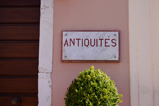 antiquites french text means shop antiques on the wall facade of store in france sells flea markets
