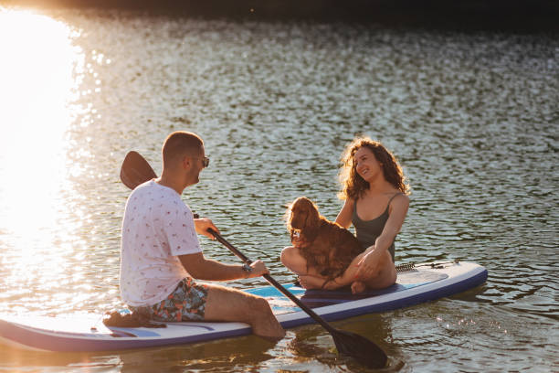 istock Young loving couple having fun while sitting on a paddle board 1410953053