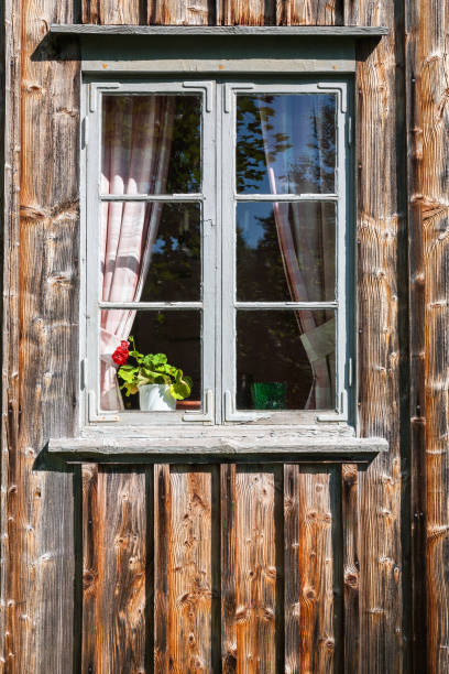 istock Window of an old cottage with a blooming geranium in the window 1410955010