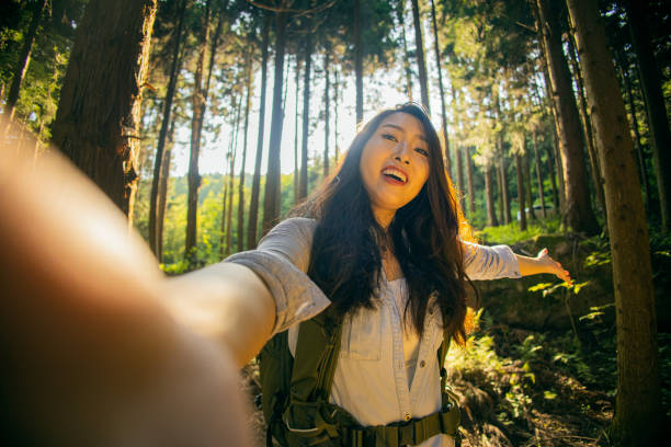 istock Young woman taking a selfie in a forest 1410956293
