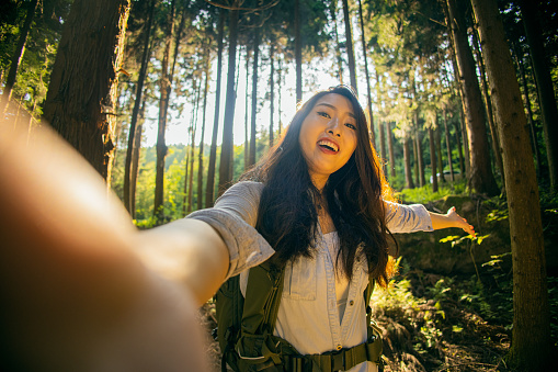 Young woman taking a selfie in a forest