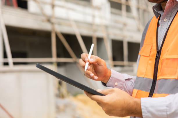 istock Close up hand engineer Using tablet for checking and maintenance to inspection at modern home building construction 1410957509