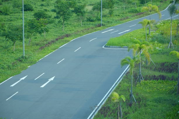 istock An empty asphalt road cuts through a green grass field 1410958389