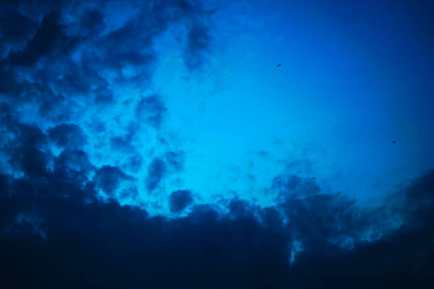 Dark blue sky with clouds. Night. Dramatic gloomy cloudy sky background with space for design. A storm is coming.