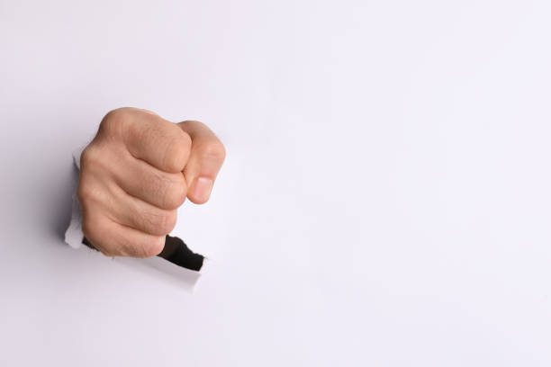 istock Man breaking through white paper with fist, closeup. Space for text 1410959471