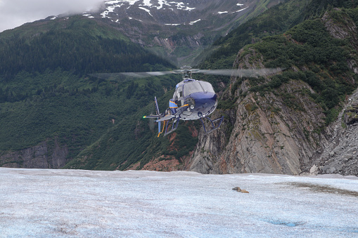 A helicopter is about to land on the Mendenhall Glacier just outside of Juneau, Alaska.