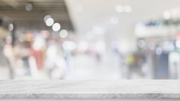 istock Empty white marble stone table top and blur glass window interior shopping mall banner mock up abstract background - can used for display or montage your products. 1410961112