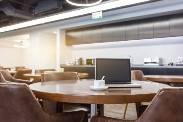 istock Meeting area in a modern creative coworking space with laptop computer, stationery, papers and coffee cup 1410961210
