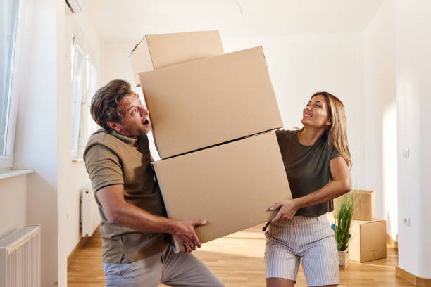 istock Couple carrying heavy boxes after moving into a new home. 1410962106