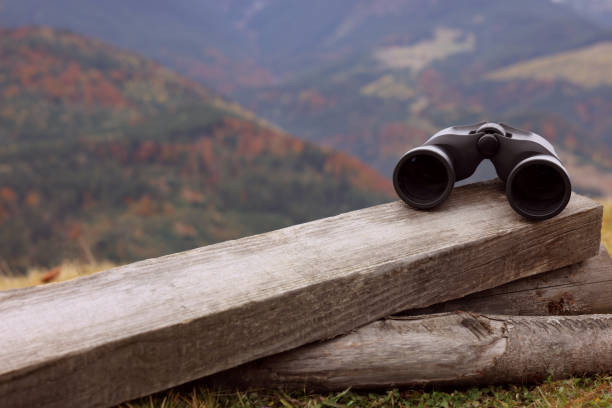 istock Binoculars on wooden fence in mountains, space for text 1410962411