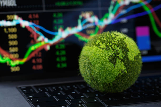 Green Globe a laptop billentyűzetén, Stock grafikonnal a laptop képernyőjén. Zöld üzleti koncepció. Szén-dioxid-hatékony technológia. Digitális fenntarthatóság. a zöldenergia-innováció jövőbeli üzleti trendje. stock fotó
