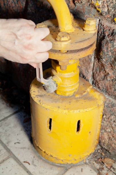 istock Hand closes yellow gas tap 1410963644