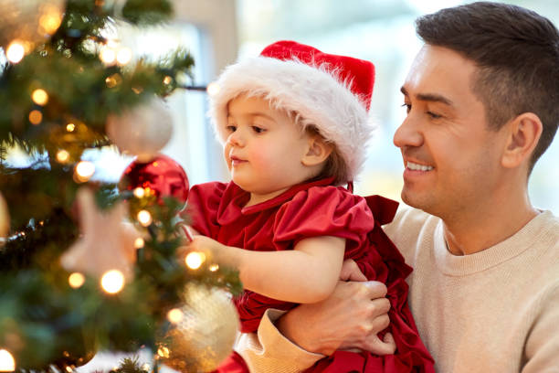 happy father and baby girl decorate christmas tree stock photo