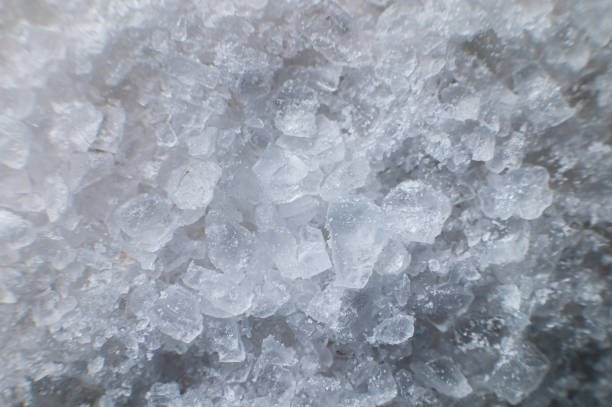 Coarse white iodized salt. Detailed background texture Macro close-up. Salt crystals of different sizes.