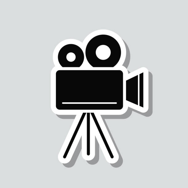 filmkamera mit stativ. symbolaufkleber auf grauem hintergrund - television camera tripod media equipment videography stock-grafiken, -clipart, -cartoons und -symbole