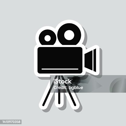 istock Movie camera with tripod. Icon sticker on gray background 1410970358