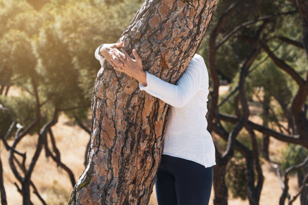 istock women embracing trees while meditating on the forest. sustainability concept. summer solstice. 1410976495