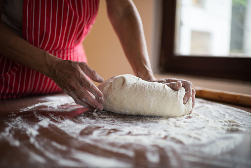 Unrecognizable senior woman preparing food at home.