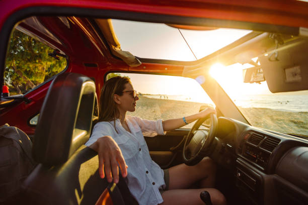 istock Young woman enjoys driving a car on vacation 1410981299