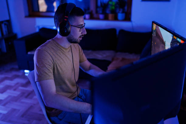 istock Young man livestreaming while playing multiplayer online game in the evening at home 1410981463