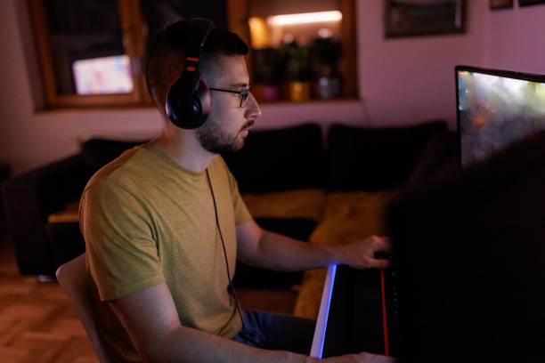 istock Young man livestreaming while playing multiplayer online game in the evening at home 1410981656