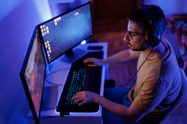 istock Young man livestreaming while playing multiplayer online game in the evening at home 1410981808