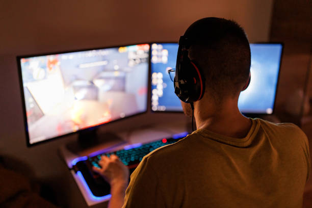 istock Young man livestreaming while playing multiplayer online game in the evening at home 1410983083
