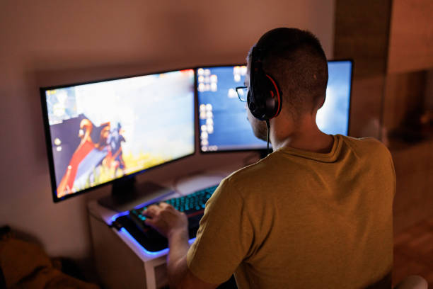 istock Young man livestreaming while playing multiplayer online game in the evening at home 1410984064