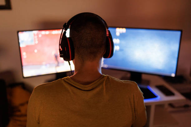 istock Young man livestreaming while playing multiplayer online game in the evening at home 1410984396