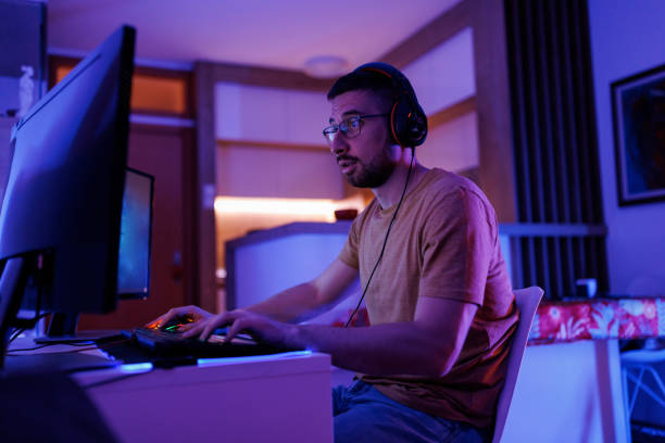 istock Young man livestreaming while playing multiplayer online game in the evening at home 1410984671
