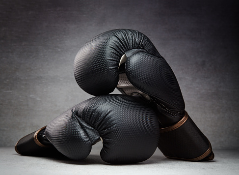 Pair of boxing gloves on concrete background in a dark environment