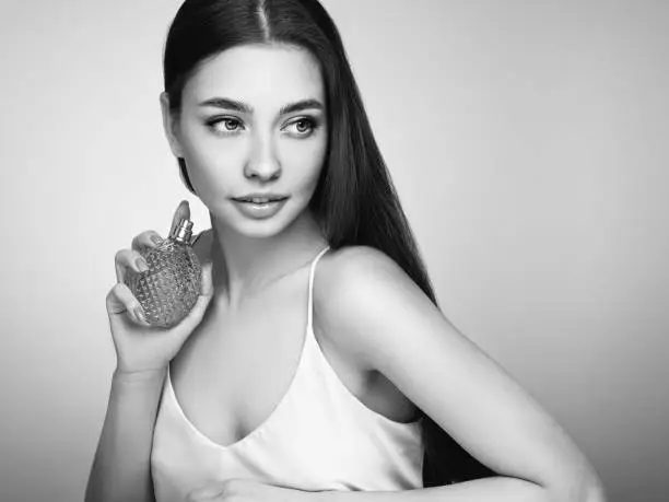 Photo of Young beautiful woman with a bottle of perfume