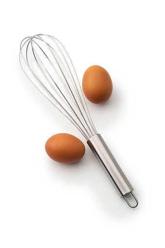 High angle view of Two eggs and whisk  isolated on a white background.