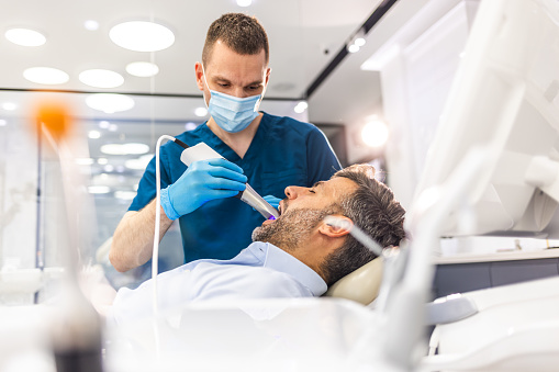 Young man patient having dental treatment at dentist's office