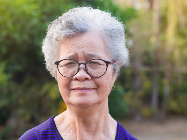 istock Senior Asian woman looking at camera while standing in a garden 1410991181
