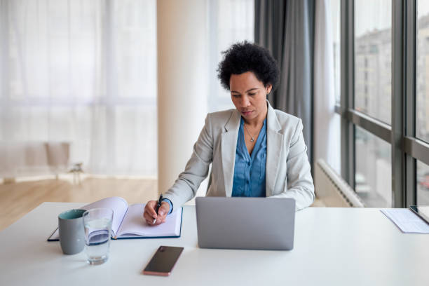 istock Serious businesswoman planning strategy while using laptop at office desk. 1410991619