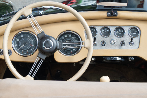 Dashboard of an English vintage vehicle finished in light leather