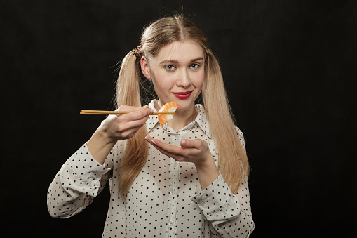 Woman with red lips is eating spaghetti