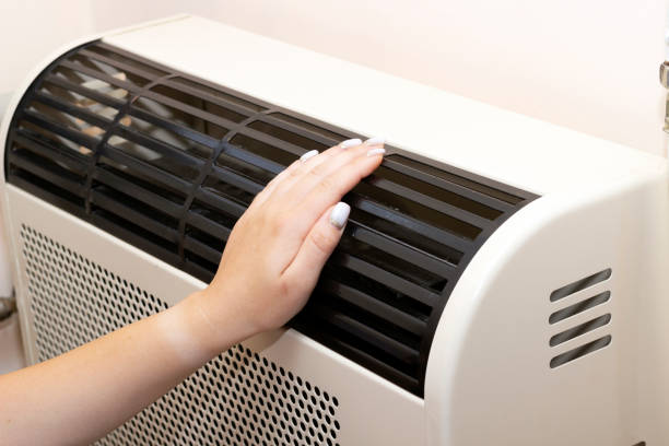 istock hard hand on the heating radiator, warm hands, check the heating robot, check the temperature, save heat in the room 1410996639