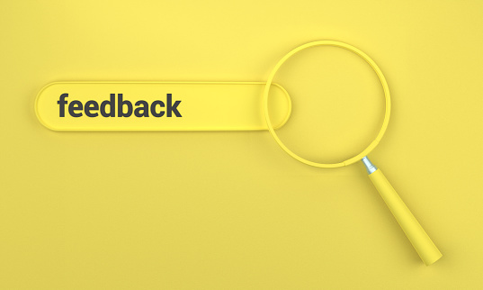 Searching for Feedback in search bar with magnifying glass. SEO concept on yellow background.